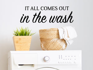Laundry room wall decal that says ‘It All Comes Out In The Wash’ in a bold font on a laundry room wall.