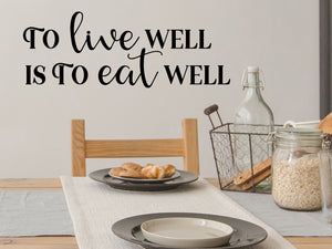 Decorative wall decal that says ‘To Live Well Is To Eat Well’ on a kitchen wall.