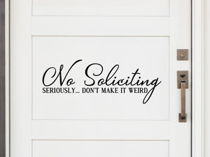 Front door decal that says, ‘No Soliciting seriously...don't make it weird’ in a script fonton a front porch door. 