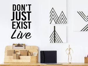 Wall decal for the office that says ‘Don't Just Exist Live’ in a bold font on an office wall.