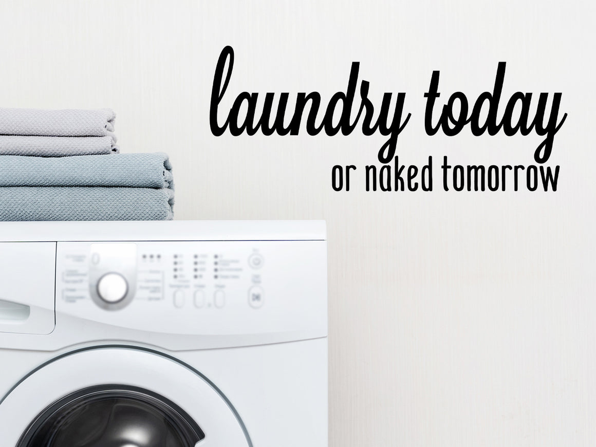 Laundry room wall decal that says ‘Laundry Today Or Naked Tomorrow’ in a cursive font on a laundry room wall.