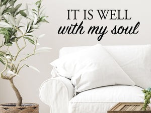 Living room wall decals that say ‘It Is Well With My Soul’ in a bold font on a living room wall. 