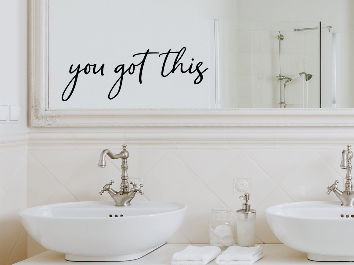 Wall decals for bathroom that say ‘You Got This’ in a cursive font on a bathroom mirror.