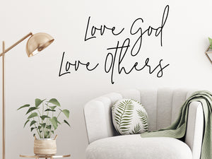 Living room wall decals that say ‘Love God love others’ on a living room wall. 