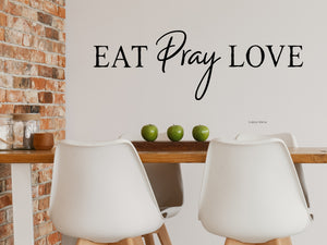 Wall decals for kitchen that say ‘Eat Pray Love’ in a print font on a kitchen wall.
