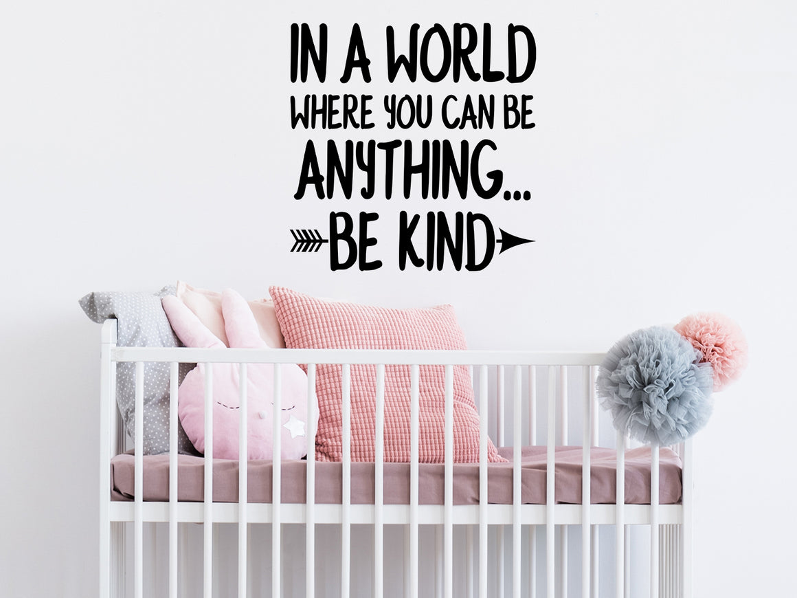 Wall decal for kids that says ‘In a world where you be anything be kind’ in a bold font on a kid’s room wall.
