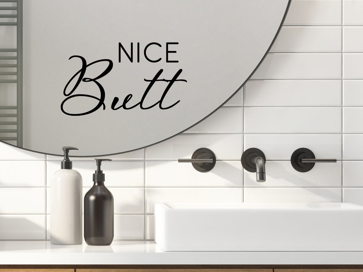 Wall decals for bathroom that say ‘Nice Butt’ in a script font on a bathroom mirror.
