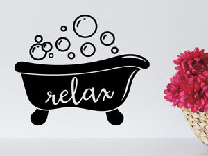 Wall decals for bathroom that say ‘relax’ with bubbles coming out of a bathtub on a bathroom wall.