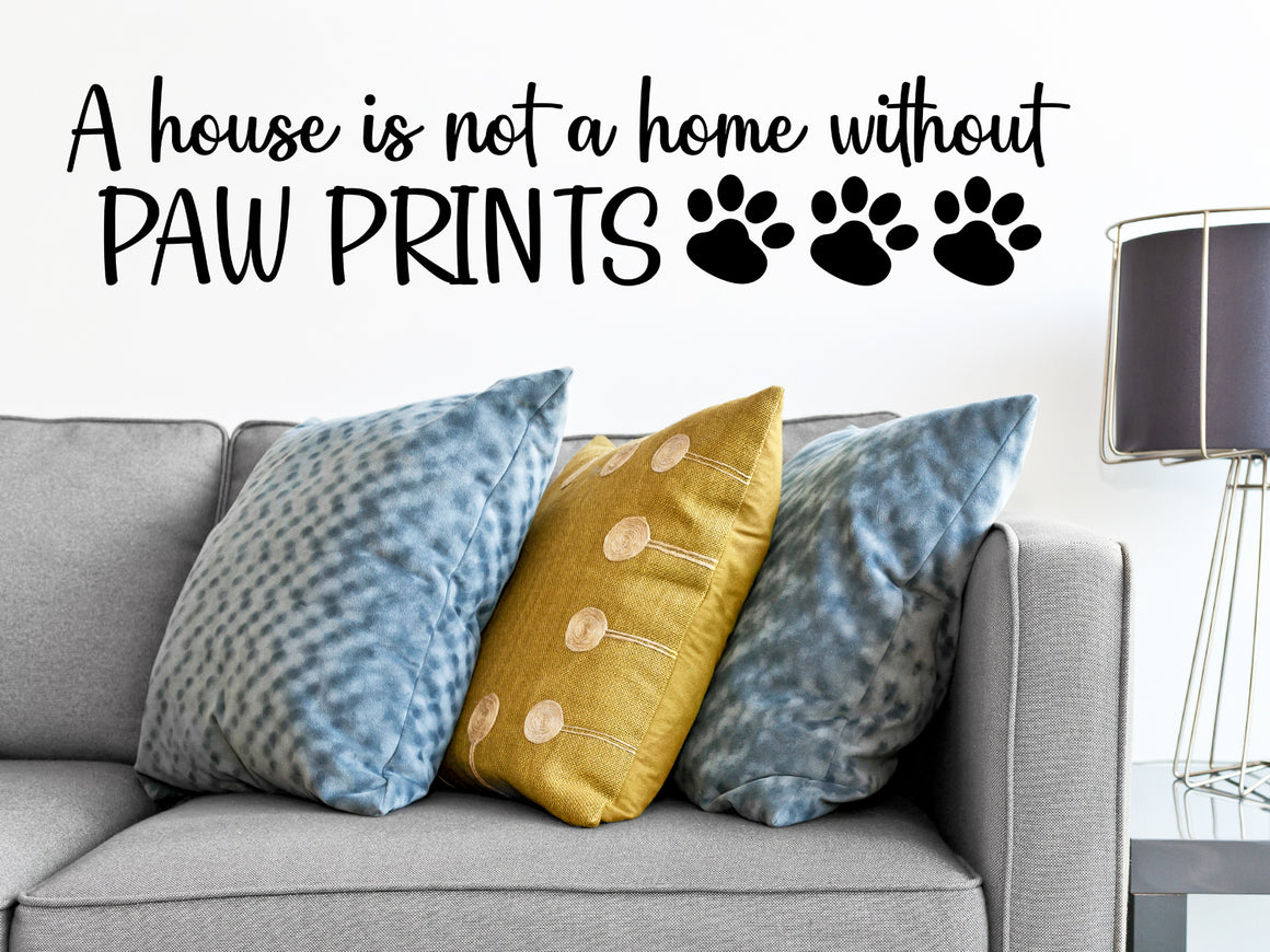 Living room wall decals that say ‘A house is not a home without paw prints’ in script fonts on a living room wall. 