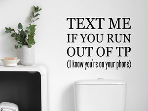 Wall decals for bathroom that say ‘Text Me If You Run Out Of TP (I Know You're On Your Phone)’ on a bathroom wall.