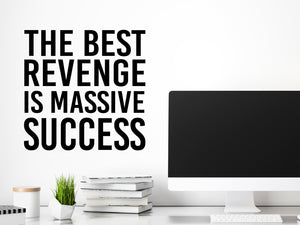 Decorative wall decal that says ‘The Best Revenge Is Massive Success’ on an office wall.