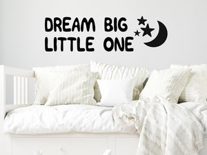 Wall decal for kids that says ‘Dream Big Little One’ in a print font on a kid’s room wall. 