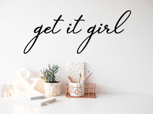 Wall decal for the office that says ‘Get It Girl’ in a cursive font on an office wall.