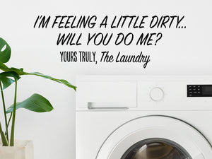 Laundry room wall decal that says ‘I'm Feeling Dirty Will You do Me? Yours Truly The Laundry’ in a print font on a laundry room wall.