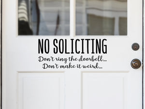 Front door decal that says, ‘No Soliciting Don't Ring The Doorbell Don't Make It Weird’ in a print font on a front porch door. 