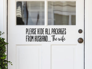 Front door decal that says, ‘Please Hide All Packages From Husband… The Wife’ on a front porch door.