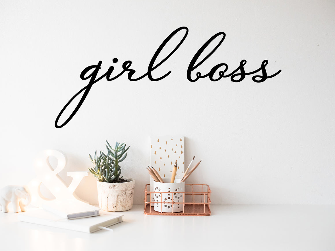 Wall decal for the office that says ‘Girl Boss’ in a cursive font on an office wall.