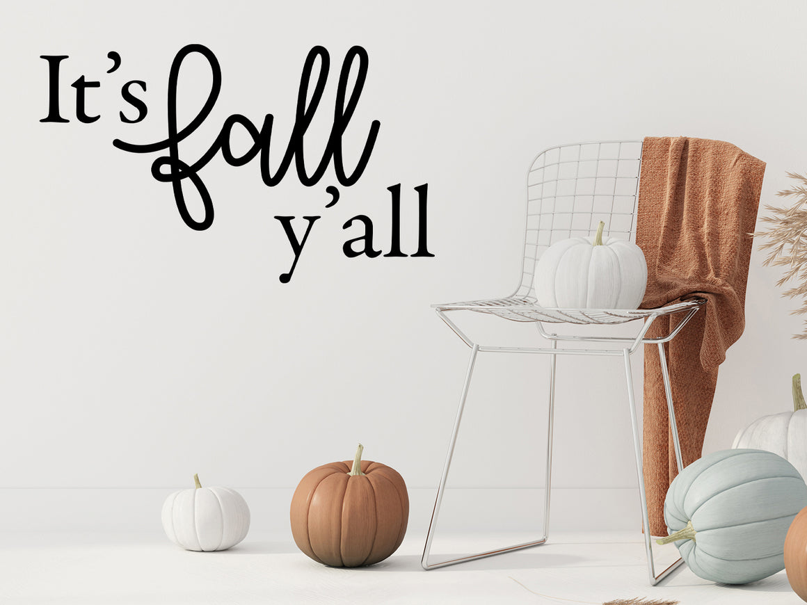 Living room wall decals that say ‘It's Fall Y'all’ in a script font on a living room wall. 