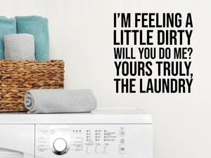 Laundry room wall decal that says ‘I'm Feeling Dirty Will You do Me? Yours Truly The Laundry’ in a bold font on a laundry room wall.