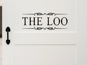 Wall decals for bathroom that say ‘The Loo’ with ribbons on a bathroom door.