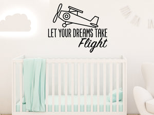 Wall decal for kids that says ‘Let Your Dreams Take Flight’ in a script font on a kid’s room wall. 