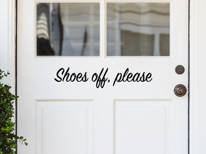 Front door decal that says, ‘shoes off please’ on a front porch door. 