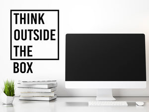 Decorative wall decal that says ‘Think Outside The Box’ on an office wall.