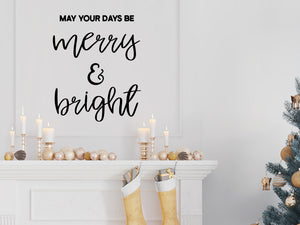 Living room wall decals that say ‘May Your Days Be Merry And Bright’ in a cursive font on a living room wall. 