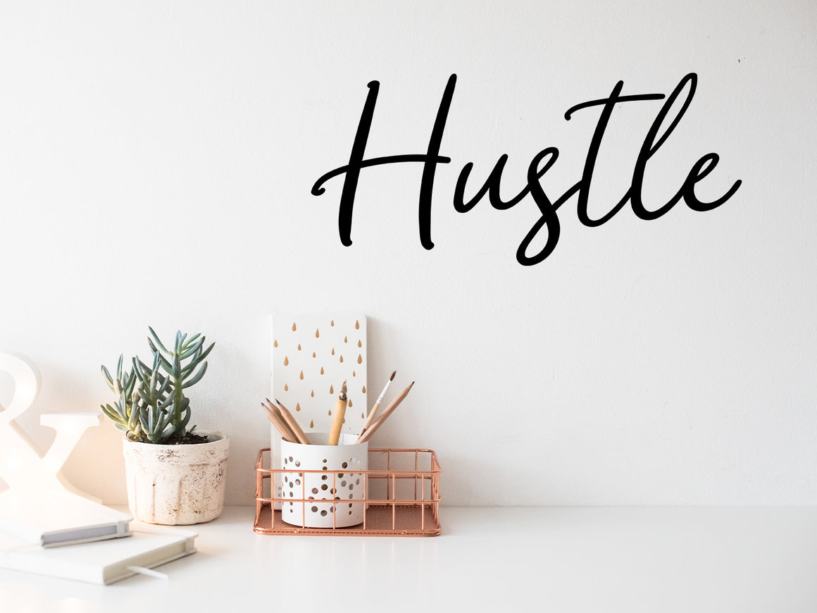 Wall decal for the office that says ‘Hustle’ in a script font on an office wall.