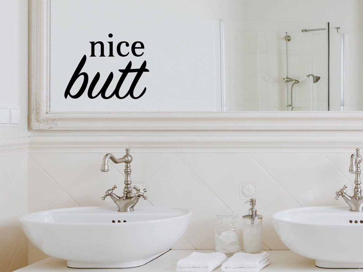 Wall decals for bathroom that say ‘Nice Butt’ in a bold font on a bathroom mirror.