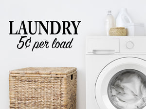 Laundry room wall decal that says ‘Laundry 5 Cents Per Load’ in a print font  on a laundry room wall
