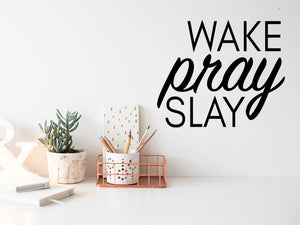 Wall decal for the office that says ‘Wake Pray Slay’ in a cursive font on an office wall.