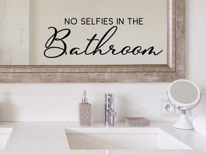 Wall decals for bathroom that say ‘No Selfies In The Bathroom’ in a script font on a bathroom mirror.