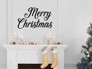 Living room wall decals that say ‘Merry Christmas’ in a cursive font on a living room wall. 