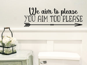 Wall decals for bathroom that say ‘we aim to please, you aim too please’ on a bathroom wall.