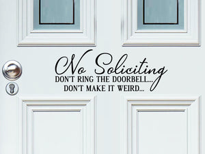 Front door decal that says, ‘No Soliciting Don't ring the doorbell don't make it weird’ on a front porch door. 