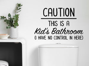 Wall decal for bathroom that says ‘Caution This Is A Kid's Bathroom (I Have No Control In Here)’ on a bathroom wall.