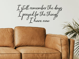 Living room wall decals that say ‘I Still Remember The Days I Prayed For The Things I Have Now’ in a cursive font on a living room wall. 