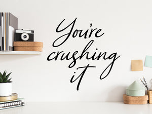 Wall decal for the office that says ‘You're Crushing It’ in a cursive font on an office wall.