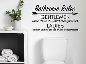 Wall decals for bathroom that say ‘Bathroom Rules (Gentleman & Ladies)’ in a cursive font on a bathroom wall.