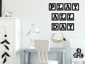 Wall decal for kids that says ‘Play All Day’ in a block design on a kid’s room wall. 
