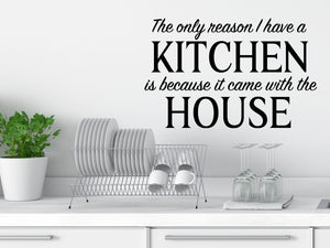 Wall decals for kitchen that say ‘The Only Reason I Have A Kitchen Is Because It Came With The House’ in a script font on a kitchen wall.