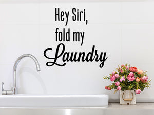 Laundry room wall decal that says ‘Hey Siri Fold My Laundry’ on a laundry room wall