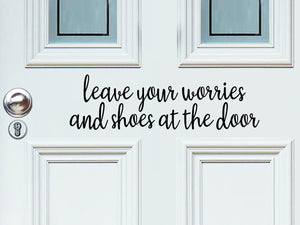 Front door decal that says, ‘Leave Your Worries And Shoes At The Door’ in a script font  on a front porch door. 
