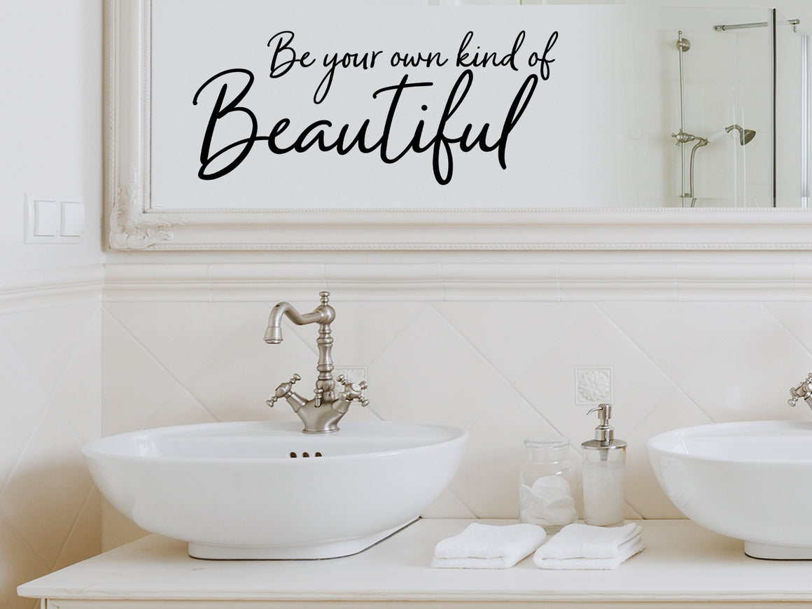 Wall decals for bathroom that say ‘Be Your Own Kind Of Beautiful’ in a cursive font on a bathroom wall.