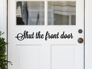 Front door decal that says, ‘Shut the front door’ on a front porch door. 
