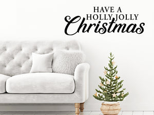 Living room wall decals that say ‘Have A Holly Jolly Christmas’ in a cursive font on a living room wall. 