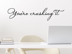 Wall decal for the office that says ‘You're Crushing It’ in a script font on an office wall.