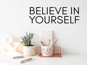 Wall decal for the office that says ‘Believe In Yourself’ in a print font on an office wall.