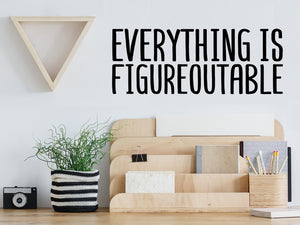 Decorative wall decal that says ‘Everything Is Figureoutable’ on an office wall.